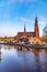 Sunset view of Uppsala cathedral reflecting on river Fyris in Sweden
