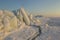 Sunset view on the winter seacoast with the stacks and piles of the ice formations