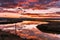 Sunset views of the tidal marshes of Alviso with colorful clouds reflected on the calm water surface, Don Edwards San Francisco