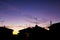 Sunset in the village with silhouettes of antennas and chimneys