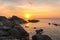 During sunset Villagers stand fishing on the rocks at Kalim Beach