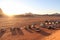 Sunset in Wadi Rum desert in Jordan with pickup trucks on sand