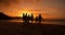 Sunset, walking and silhouette of people at the beach on a summer vacation, holiday or weekend trip. Travel, evening and