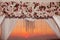 Sunset. Wedding ceremony arch decor closeup with flower arrangement and crystals chandelier decorated white curtain above sea, o