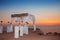 Sunset. Wedding ceremony arch with flowers decorative arrangement and white curtain on cliff above sea, sunrise outdoor summer ph