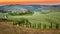 Sunset and winding road with cypresses in Tuscany