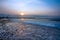 Sunset, windmill, stones and surf