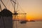 Sunset at windmills of Mykonos and yacht cruise