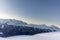 The sunset in winter during a wind storm with the snow being blown away on a peak near Lenzerheide in Switzerland