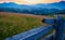 Sunset and wooden fence along pasture in the ranch, nature, summer landscape in carpathian mountains, spruces on hills, beautiful