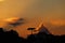 Sunset with yellowish sky full of orange clouds, with tropical rainforest in the background