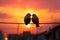 Sunsets hues backdrop bird couples silhouette on wire, a love story
