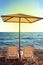 Sunshades and chaise lounges on beach. Summer seascape.
