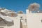 Sunshades in Greece - Santorini. White sunshades against white walls on terraced hotel outdoor area