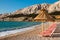 Sunshades and orange deck chairs on beach at Baska - Krk