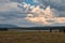 Sunshine breaking through stormy clouds over meadow