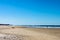 Sunshine Coast beach in Australia with unreognizable people silhouetted in the distance, including one man on a laptop