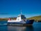 In sunshine, the interisland car ferry MV Bigga on Bluemull Sound between Yell and Unst, in Shetland, UK