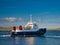 In sunshine, the interisland car ferry MV Bigga on Bluemull Sound between Yell and Unst, in Shetland, UK