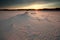 Sunshine over windy sand dunes at sunset