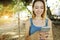 Sunshine portrait of young blonde girl chatting by smartphone and riding swing in Bali, sand in background.