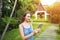 Sunshine portrait of young woman using tablet and smiling on green palms and house background in Thailand