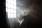 Sunshine window reflection on the wooden floor. Heavy smoke in loft design studio. Cinematic photo