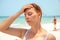 Sunstroke woman on sunny beach. Woman with headache. Hot sun danger. Health problem on holiday