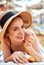 Suntan   woman in hat applying sunscreen solar. Beautiful happy woman smear  lotion  with sun cream   to her nose