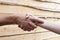 Suntanned male and female hands make handshake