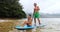 SUP - couple on stand up paddle board doing ocean watersport activity