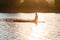 Sup surfer sits on the sup board in the golden light