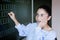 Supdrised girl in glasses stays near blackboard in classroom