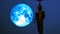 Super blue harvest moon moving on night sky and silhouette buddha