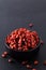 Super brain food dry Goji berry in black ceramic cup on slate stone board with copy space