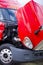 Super bright red modern semi truck engine under open hood