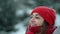 super close up happy smiling woman in knitted hat and scarf in snowy winter park at frizzy day with snowflakes. woman