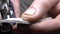 Super closeup. male hands make a hole in a leather product with a hole punch