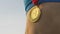 Super closeup shot of gold medal hanging on female athlete\'s neck, winner