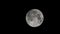 Super full moon moving through night sky