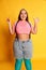 Super happy. Portrait of young overweight woman in casual bright clothes posing with smile over vivid yellow studio