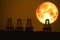 super harvest moon on night sky back  over silhouette cranes in seaport