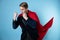 Super man fights with enemies. Businessman in a suit with a red cape,