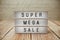 Super Mega Sale word in light box on wooden background