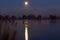 The super Moon is during the cold dawn reflected in the water of the Zoetermeerse plas in Zoetermeer, Netherlands