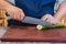 Super sharp Japanese kitchen knife cut zucchini into ultra thin slice on wooden chopping board