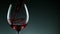 Super Slow Motion Detail Shot of Pouring Red Wine from Bottle on dark Background.