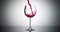 Super slow motion high speed shot of red wine flowing into a big bordeaux wineglass