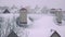 Super slow motion pan shot of snowstorm above sloped roofs of residential houses in winter