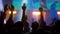 Super slow motion: silhouettes of people partying at concert in front of stage